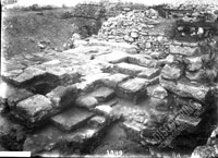 Ancient (Hellenistic) courtyard with well, pavement and remains of walls of adjoining rooms