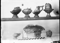 Below, shard of VESSEL of unclear shape, shoulder of fluted oinochoe decorated with eggs applied by thin clay and scratching, aryballos without neck